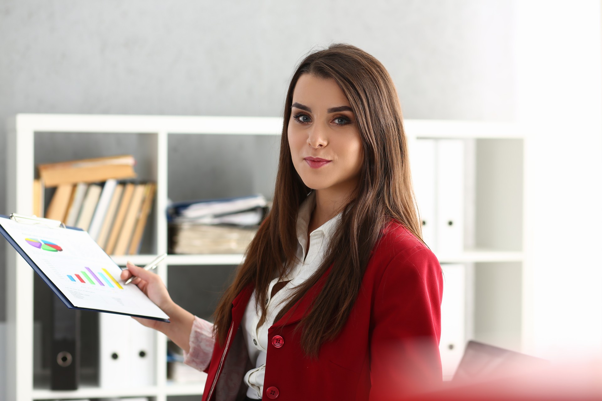 Beautiful businesswoman is holding financial analytics in charts